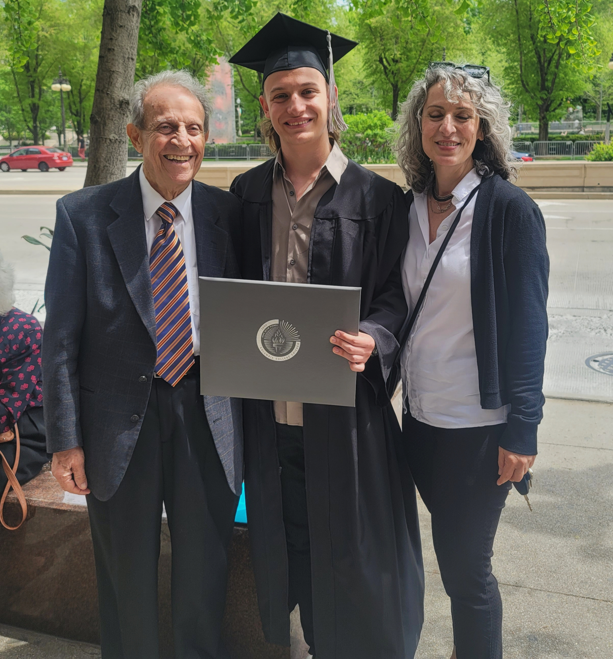 JoJo Scanlon (center) standing with his grandfather Issa Odeh (left) and mother Elaine Odeh (right) after graduating from Columb JoJo Scanlon (center) standing with his grandfather Issa Odeh (left) and mother Elaine Odeh (right) after graduating from Columbia College Chicago
